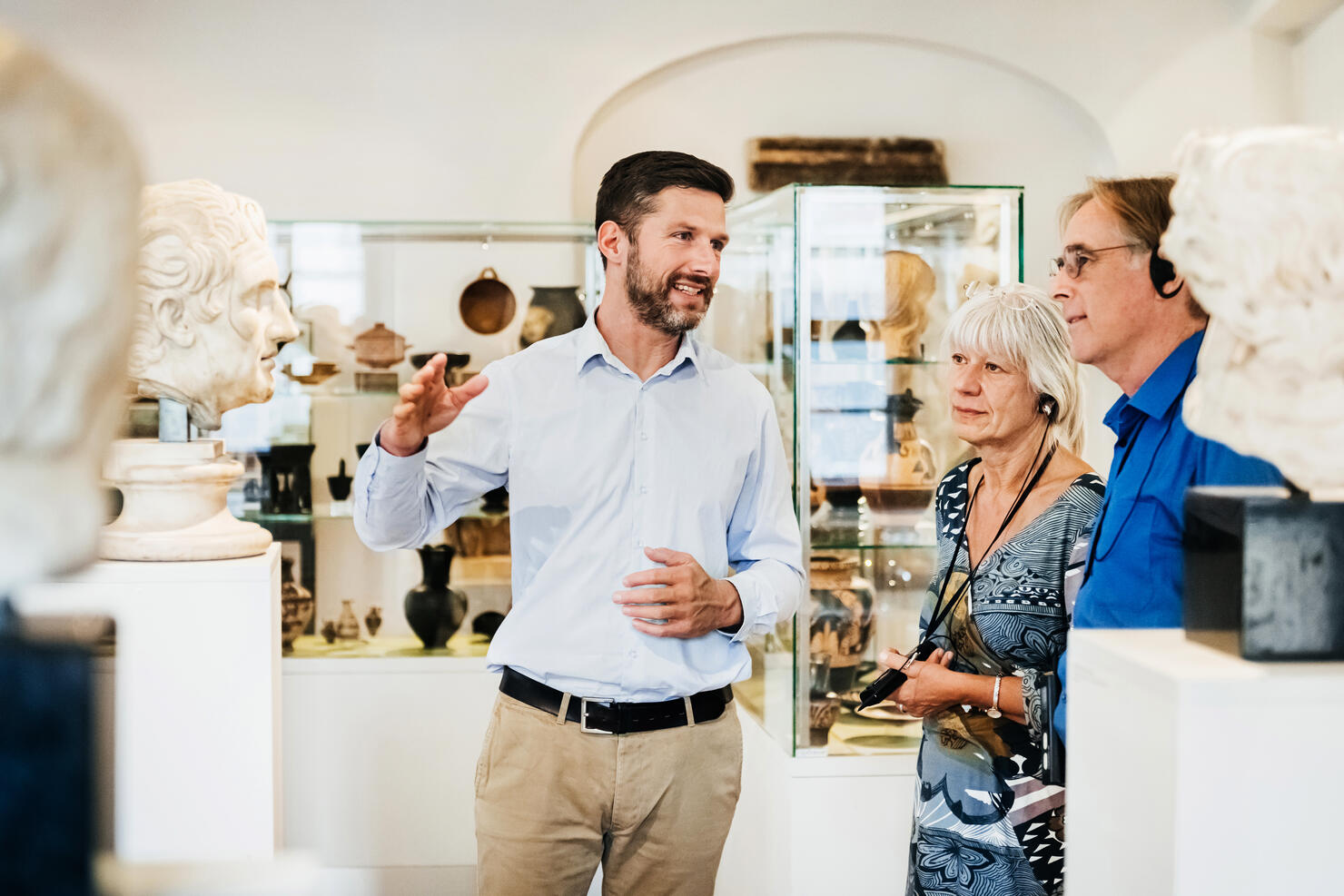 Museum Curator Explaining Exhibit To Visitors
