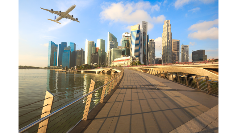 Travel, Transportation concept - Airplane flying over Singapore city in morning time