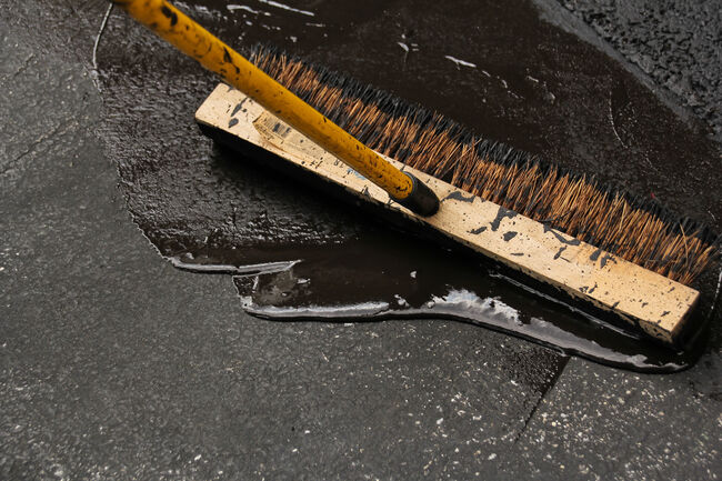 Asphalt driveway sealing with flat brush