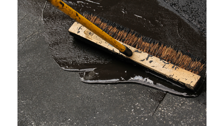 Asphalt driveway sealing with flat brush