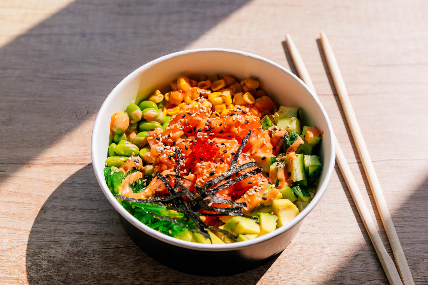 Poke bowl with salmon and edamame beans, side view