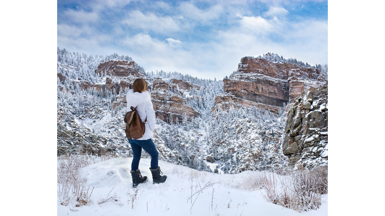 Girl hiking in the mountains on winter trip in Colorado mountains.