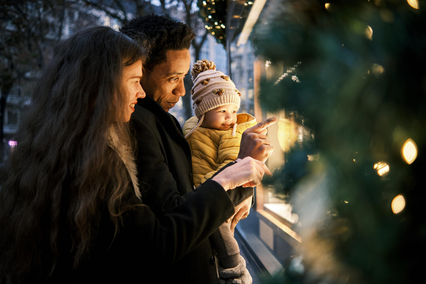 Happy interracial family enjoying doing christmas shopping together in the city.