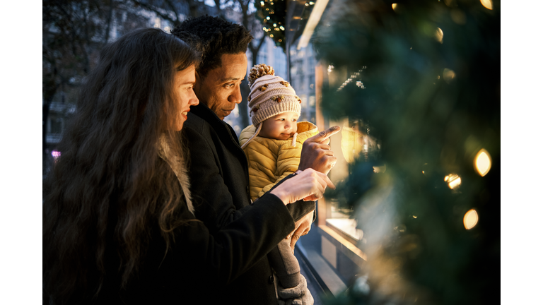 Happy interracial family enjoying doing christmas shopping together in the city.