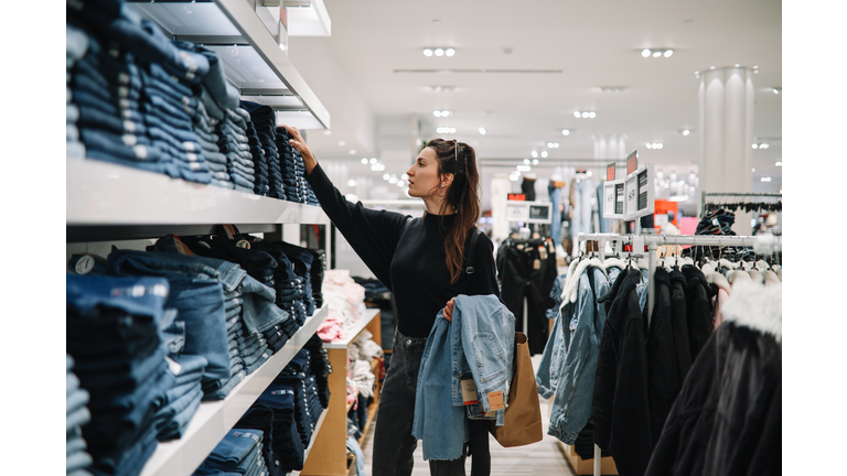 woman shopping denim jeans in a clothing store