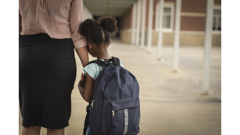 Elementary, African American girl with mom on first day of school.