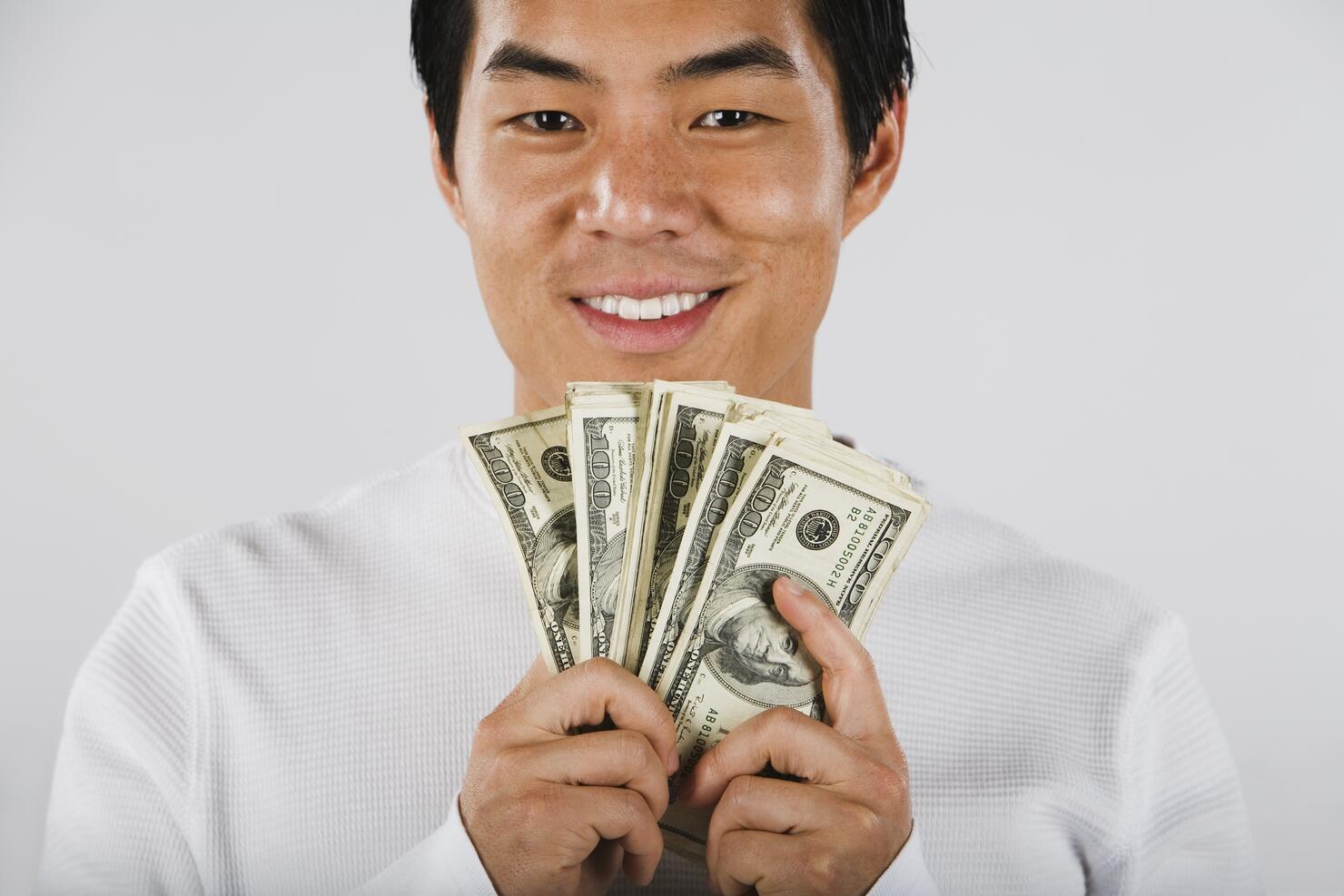 Portrait of Asian man holding wad of money