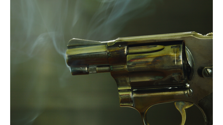 revolver gun with smoke after shoot on black background