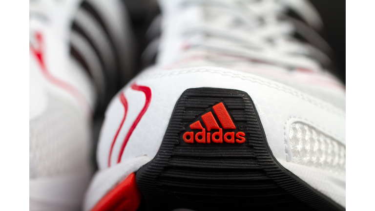 Red front Adidas logo on white running shoe