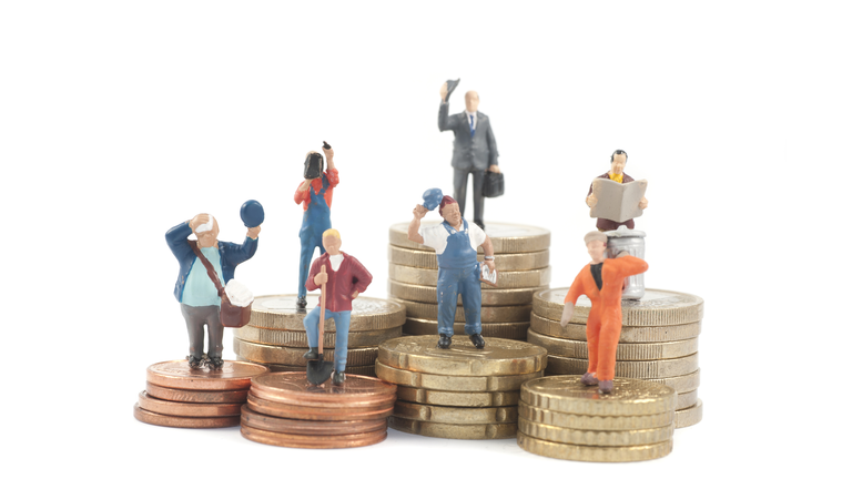 Miniature business people on stacks of coins