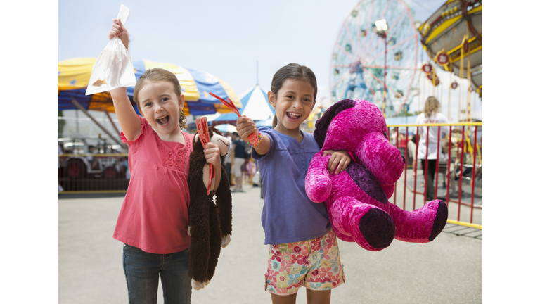 Enthusiastic girls cheering with candy at amusement park