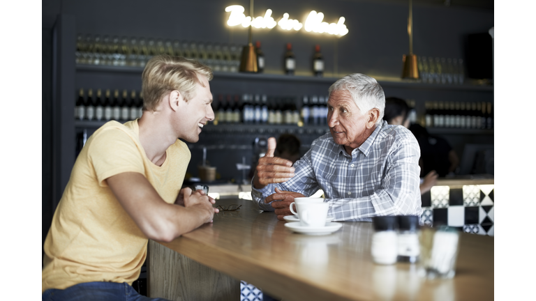 Father and son having coffee at cafe