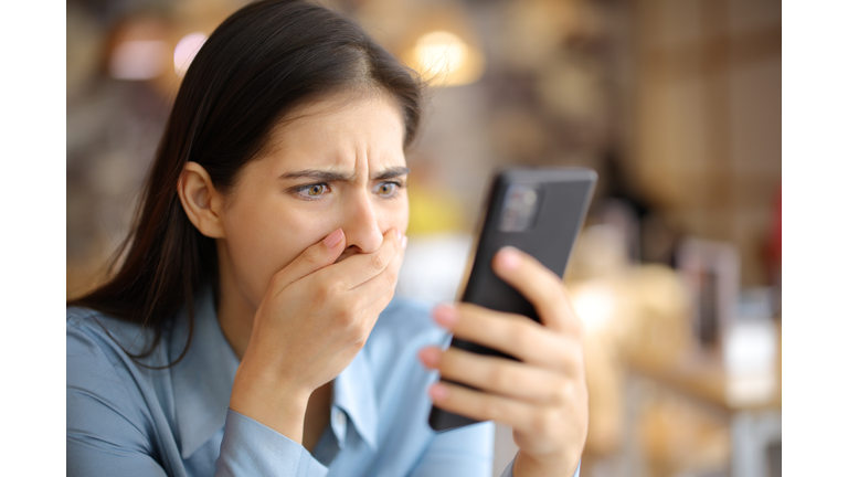 Terrified woman watching media content on phone