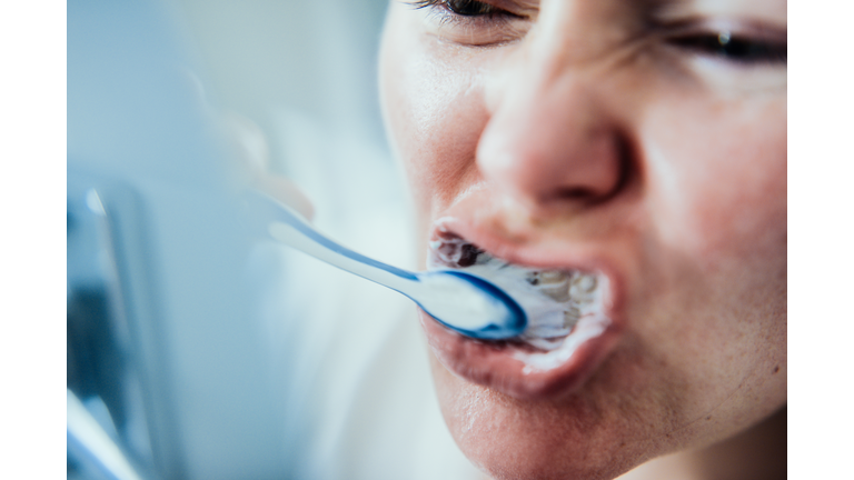 Woman brushing teeth.