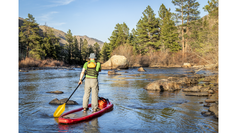 stand up paddling on mountain river