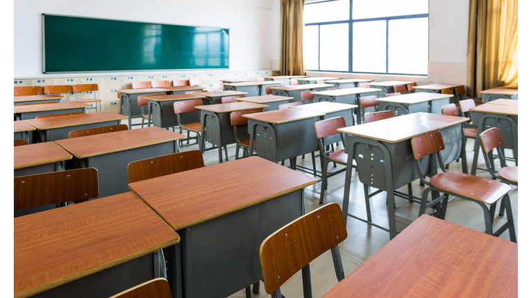 Empty classroom with desks, chairs and chalkboard