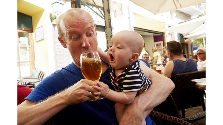 Baby trying to drink beer