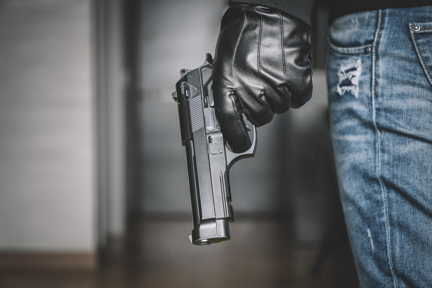 Killer with gun while waiting someone inside the house. Robbery concept Close up.