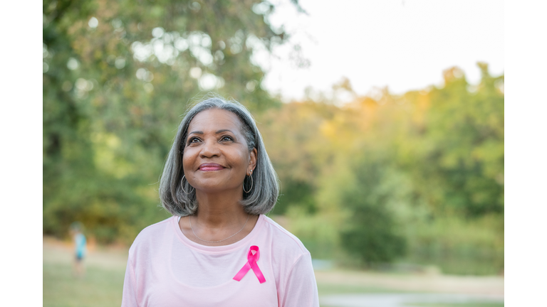 Beautiful senior woman smiles while walking for breast cancer awareness