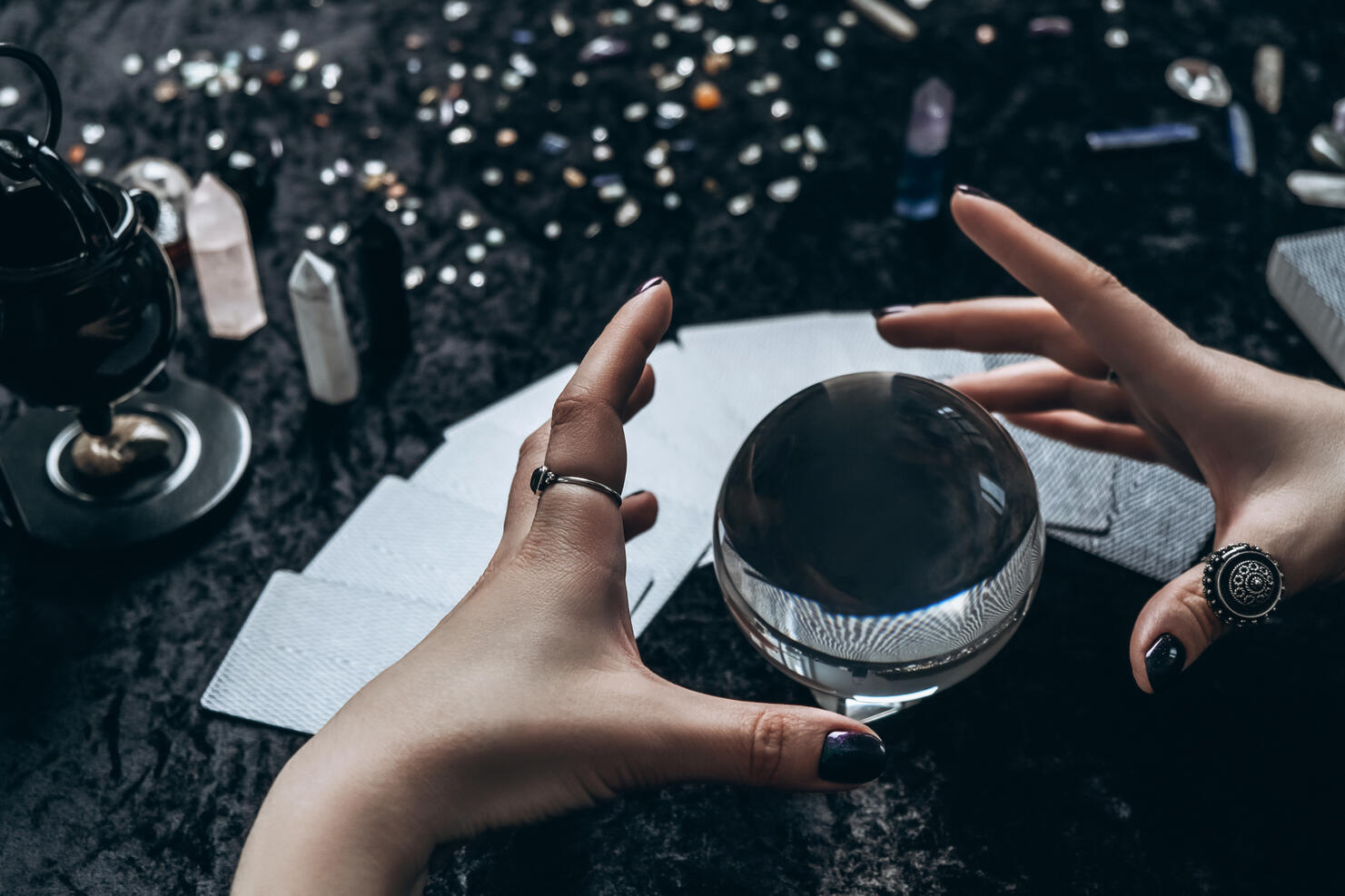 Women's hands conjure around a transparent sphere