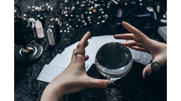 Women's hands conjure around a transparent sphere
