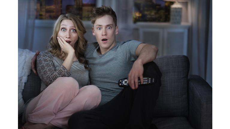 Young couple watching TV at night