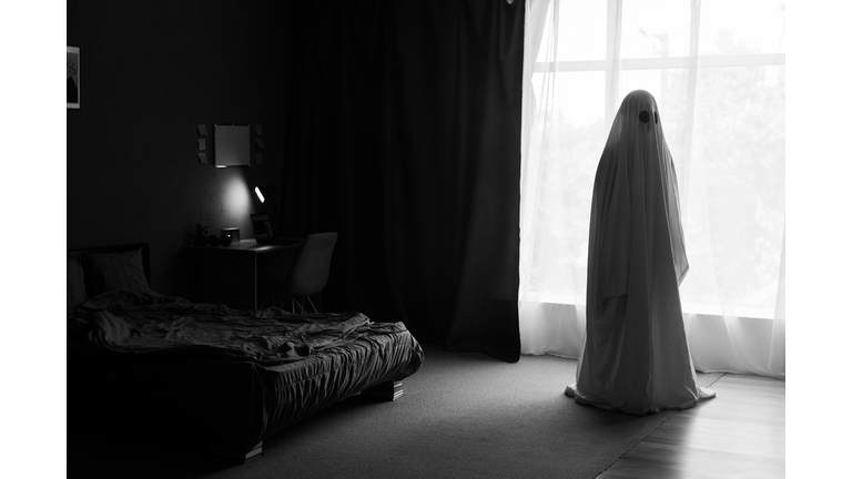 Silhouette of ghost in window inside bedroom at night. Horror scene. Halloween concept.