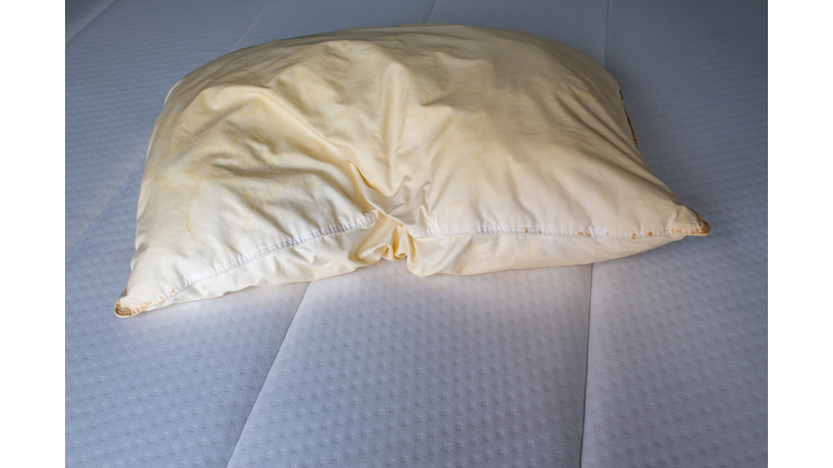 Dirty stained pillow on new white bed, Close up shot, Selective focus, Bedroom cleaning concept