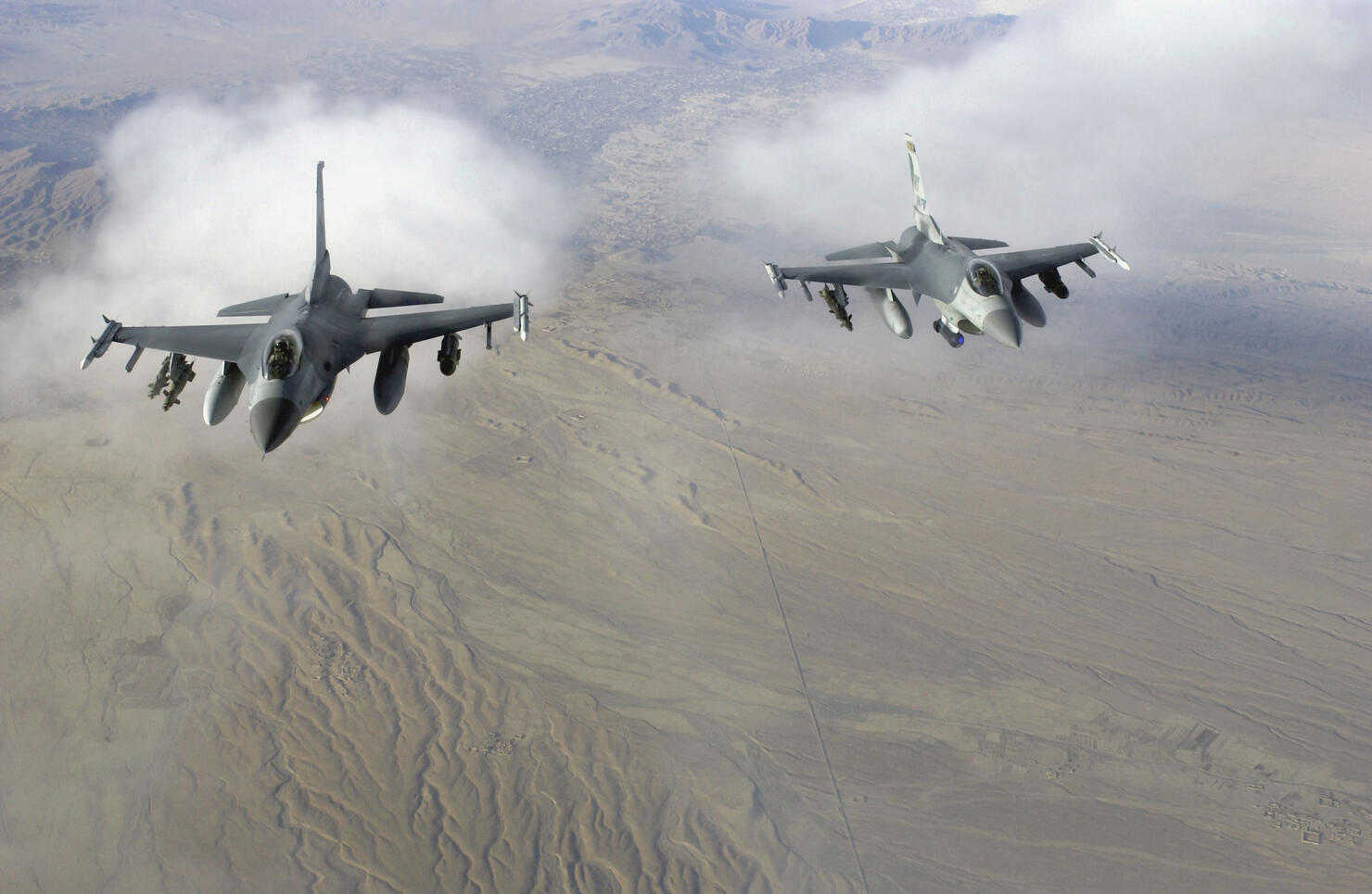 A pair of US Air Force F-16C Fighting Falcons, 174th Fighter Wing (FW), New York Air National Guard (NYANG), Syracuse, New York (NY), in flight over Afghanistan in support of Operation Enduring Freedom.