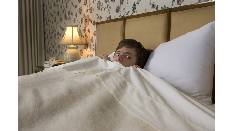 Man in bed with nervous look