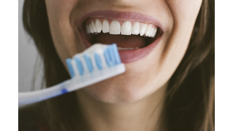 Young woman brushing teeth