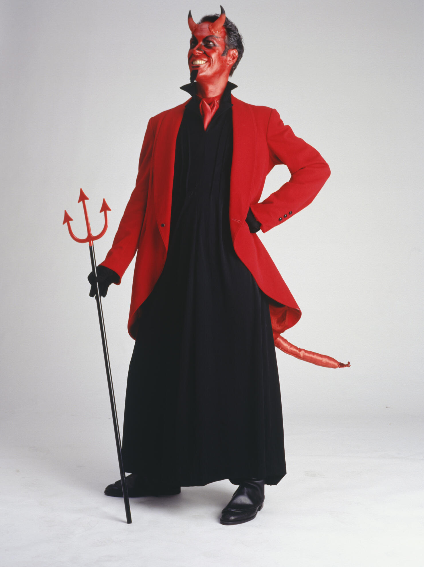 Man in devil costume standing, smiling