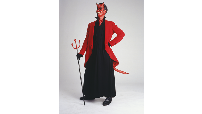 Man in devil costume standing, smiling