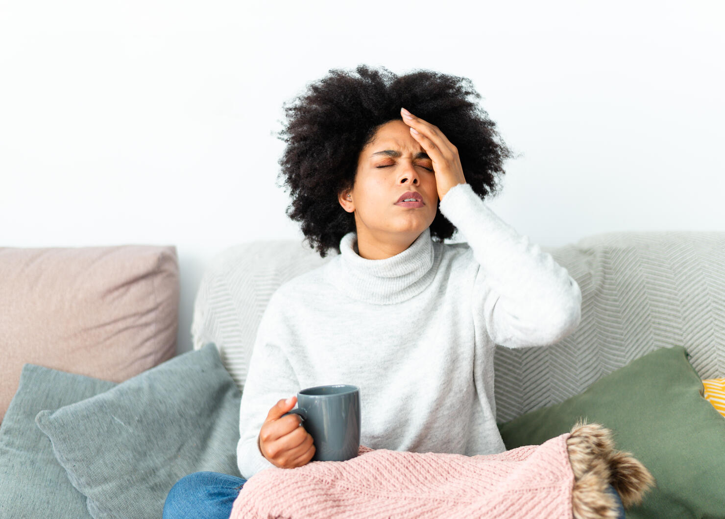 Woman gesturing headache sitting on the sofa