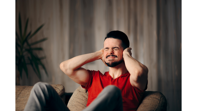 Man Covering Ears Protecting Himself from Neighbor Noise