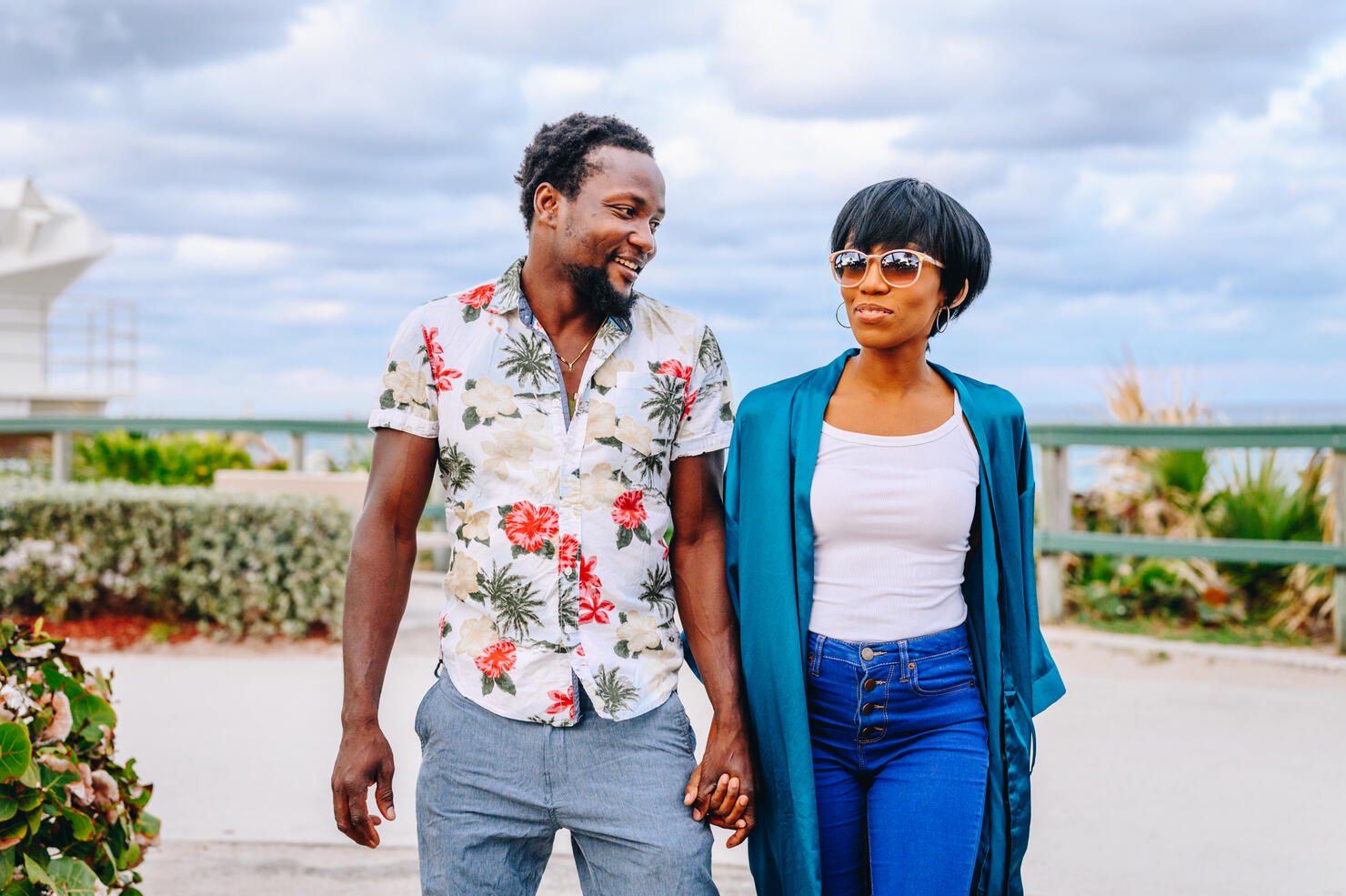 Happy cute young African American couple hold hands on a vacation or on honeymoon in a tropical location