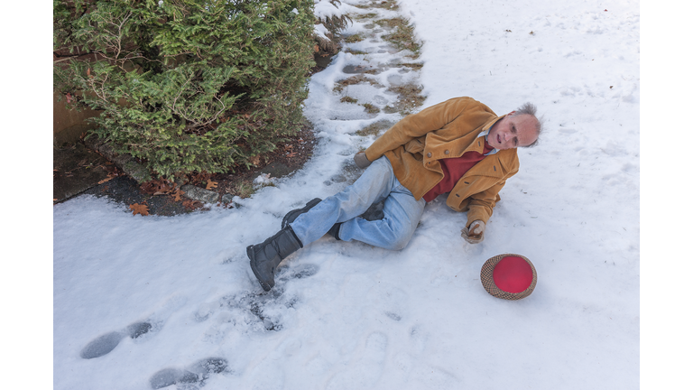 Senior man slipping on ice on his walkway