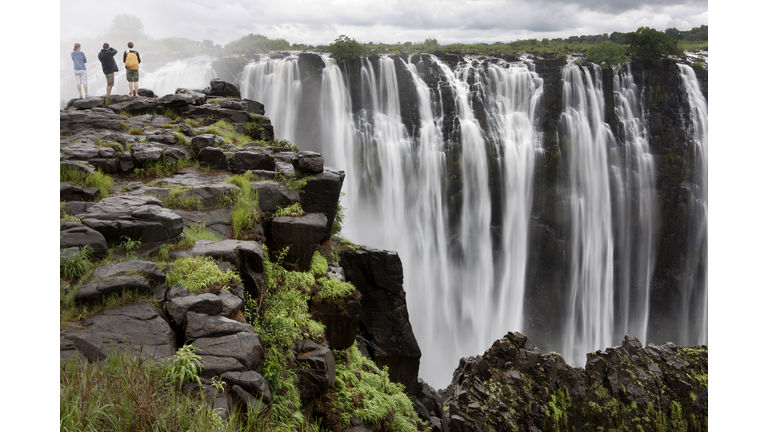 Three people looking at Victoria Falls, Zimbabwe,