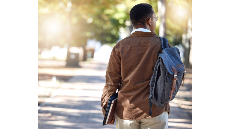 Black man, walking or backpack on campus, park nature or garden for college, university or school studying development. Student, gen z and person with learning books, education bag or growth mindset