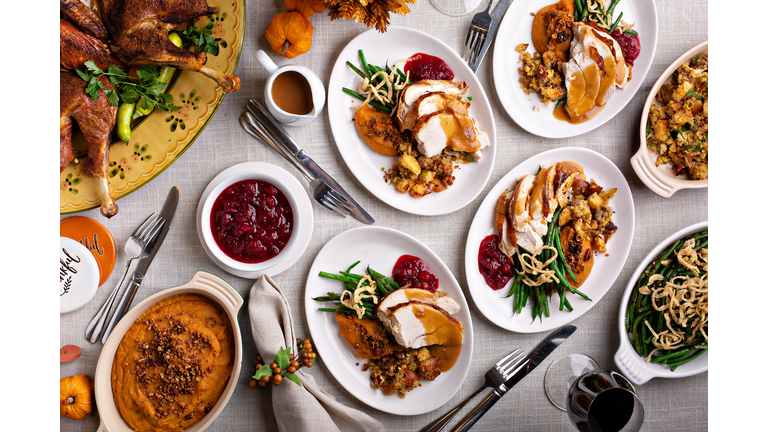 Festive Thankgiving dinner table with plates of food