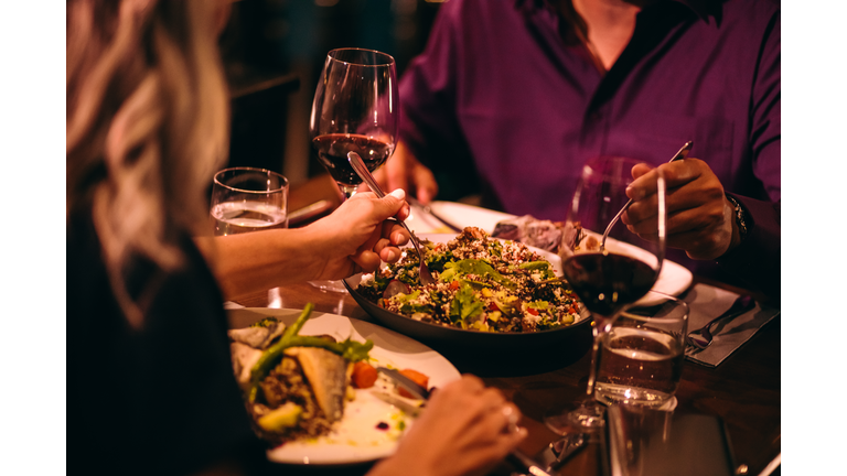 Couple eating quinoa salad and healthy dinner at restaurant