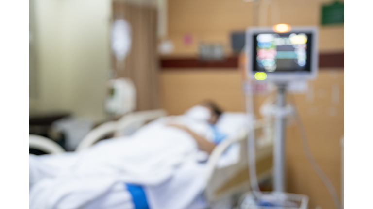 Patient on hospital bed, medical blur interior background white room ward with nursing care or healthcare recovery treatment