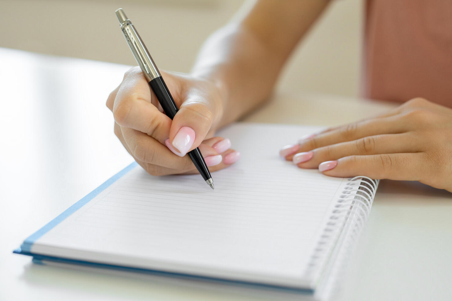 Hands writing notes on notebook