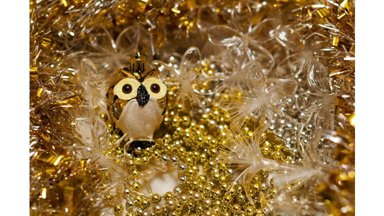 Christmas decoration. Decoration on the Christmas tree in the form of an owl. Surrounded by beads and garland