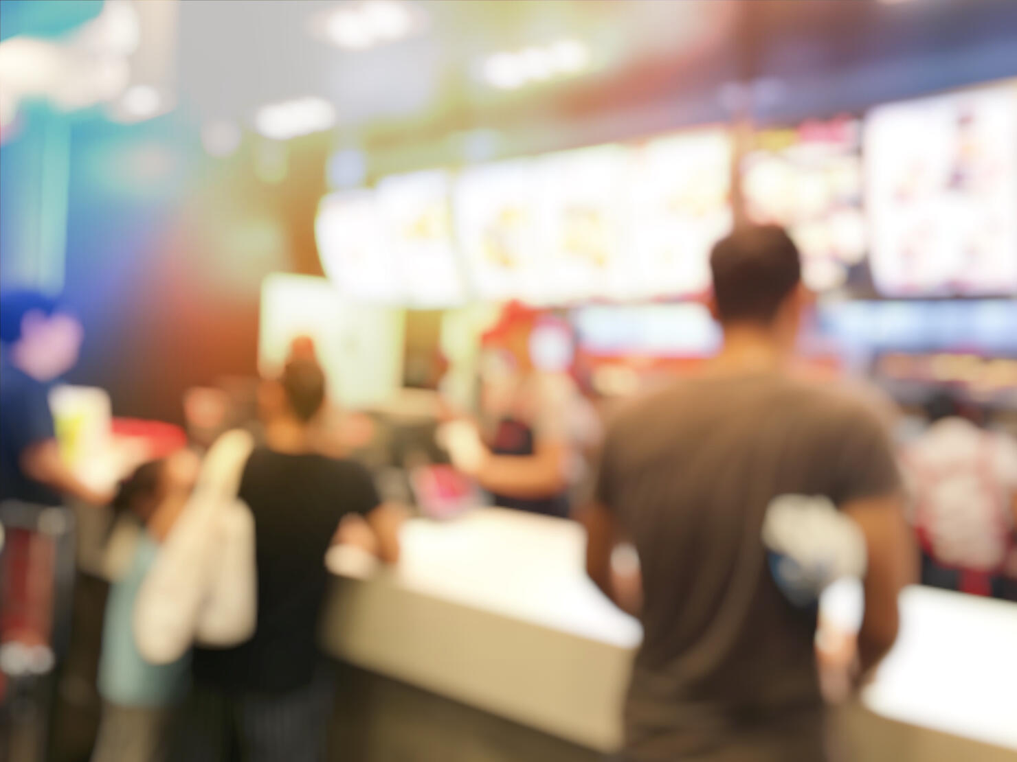 blurred image of people or customer waiting and queuing for order some food and make payment in Fastfood Store at cashier. vintage tone and light effect.