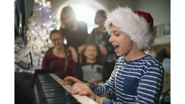 Little boy playing and singing carols on Christmas