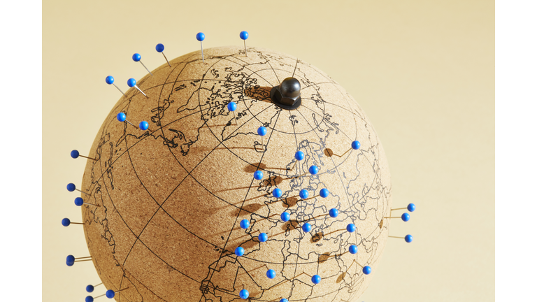 A world globe with many pins in different global locations