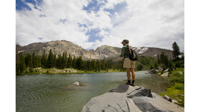 Man flyfishing high mountain lake in Colorado