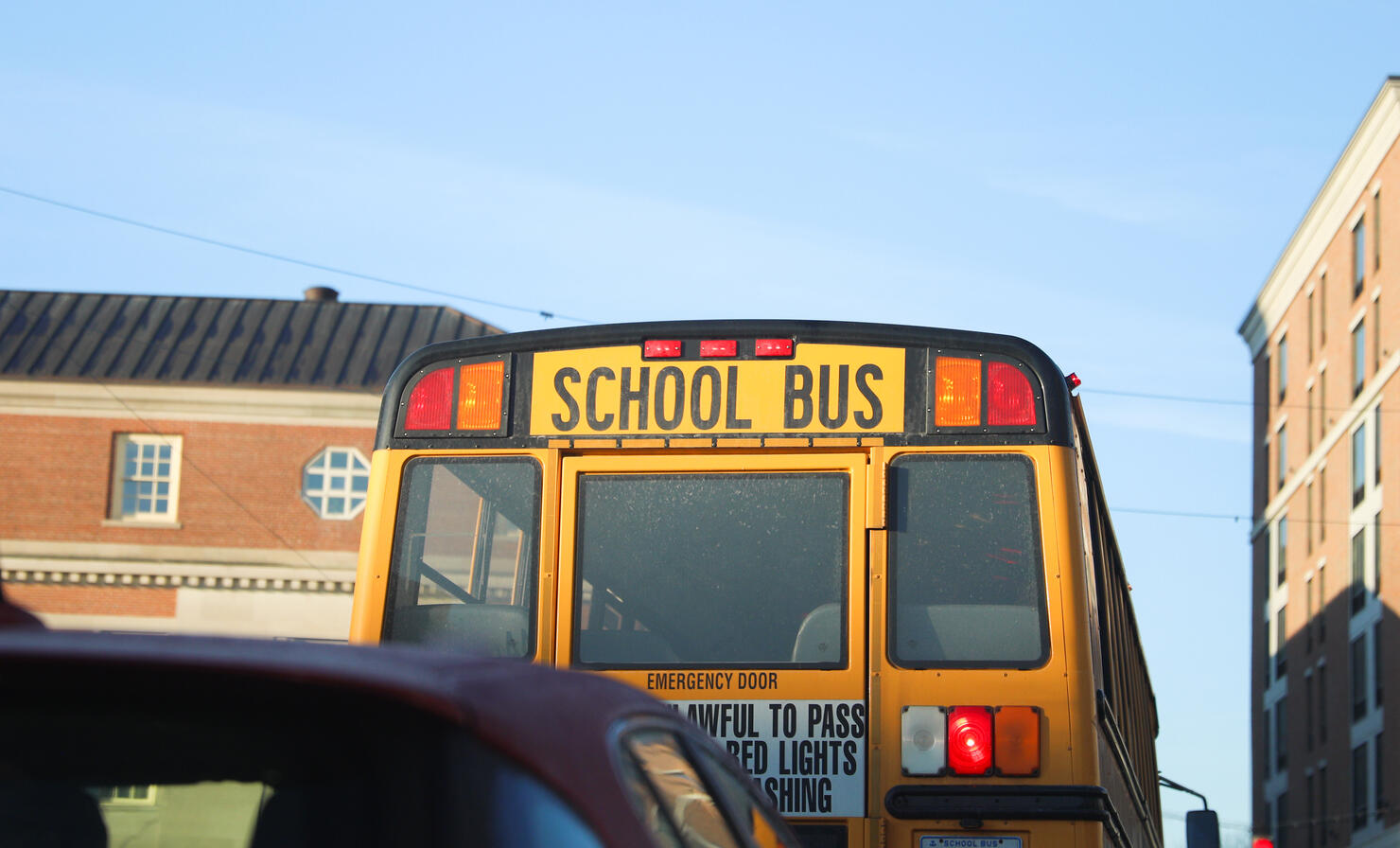 yellow school bus parked on a quiet suburban street. The bus is bright yellow with tinted windows and a stop sign on the side. photo conveys a sense of safety and nostalgia.