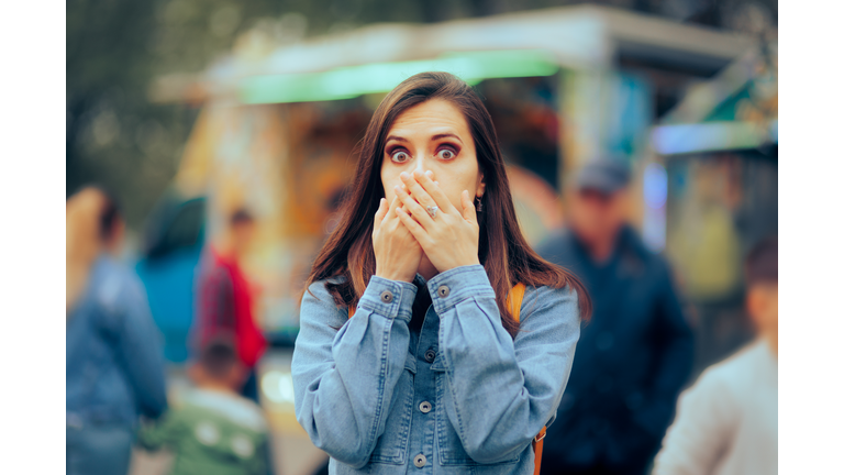 Woman feeling Sick Covering her Mouth at Local Funfair